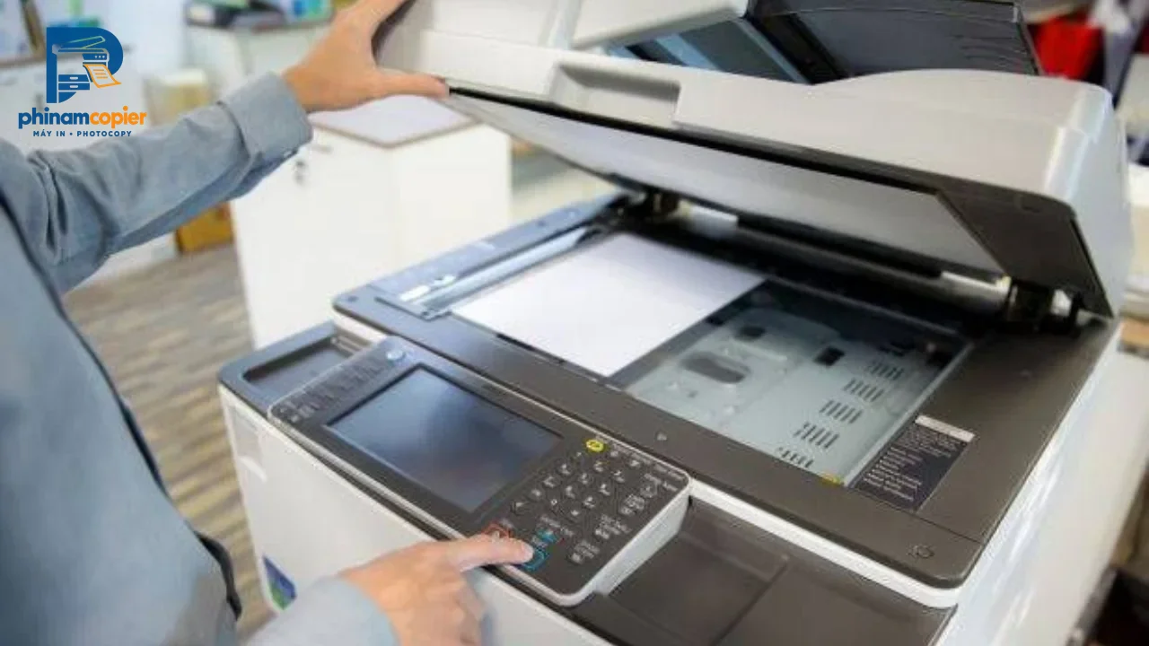 Người dùng nhấn nút trên máy photocopy đa chức năng trong văn phòng