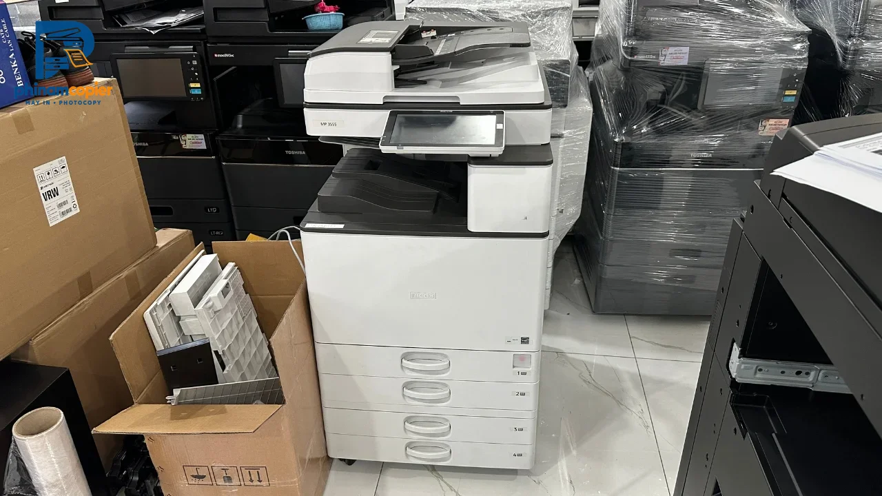 Kho máy photocopy và thiết bị văn phòng đã qua sử dụng, nhiều máy xếp chồng, thùng carton